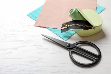 Photo of Set of tailoring accessories and fabric on light background