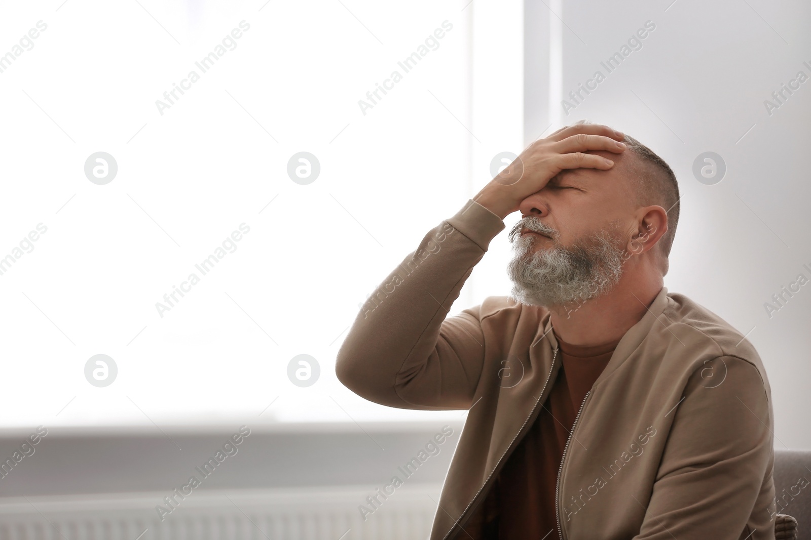 Photo of Senior man in state of depression indoors