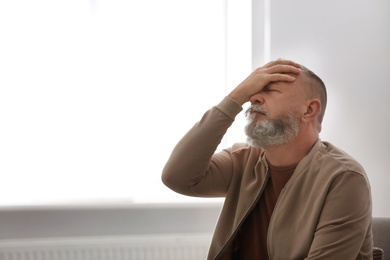 Photo of Senior man in state of depression indoors