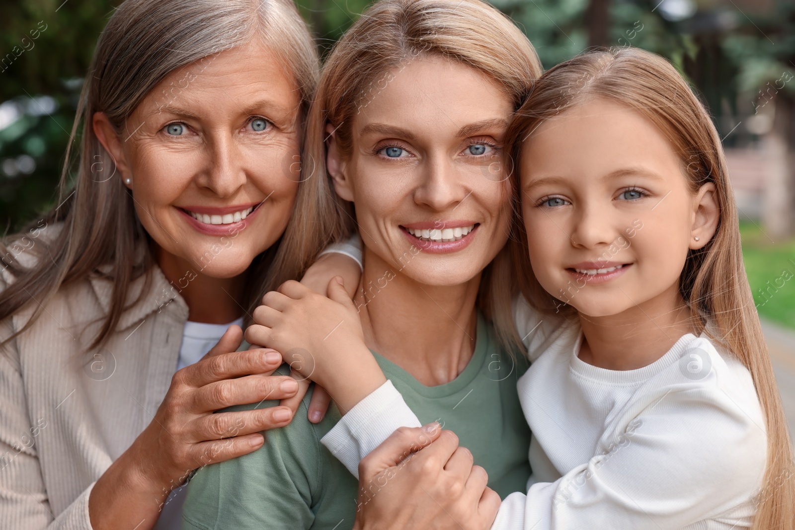 Photo of Three generations. Happy grandmother, her daughter and granddaughter outdoors