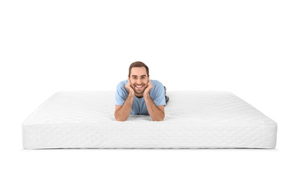 Photo of Young man lying on mattress against white background