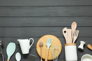 Photo of Set of different kitchen utensils on grey wooden table, flat lay