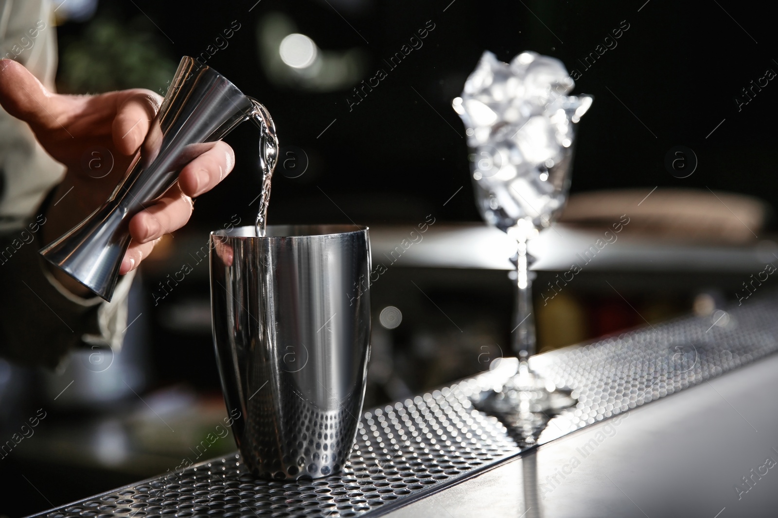 Photo of Barman pouring martini into shaker on counter, closeup with space for text