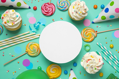 Photo of Flat lay composition with cupcakes and blank card on light green background, space for text. Birthday party