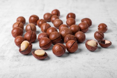 Photo of Delicious organic Macadamia nuts on white textured table