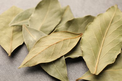 Aromatic bay leaves on light gray table, closeup
