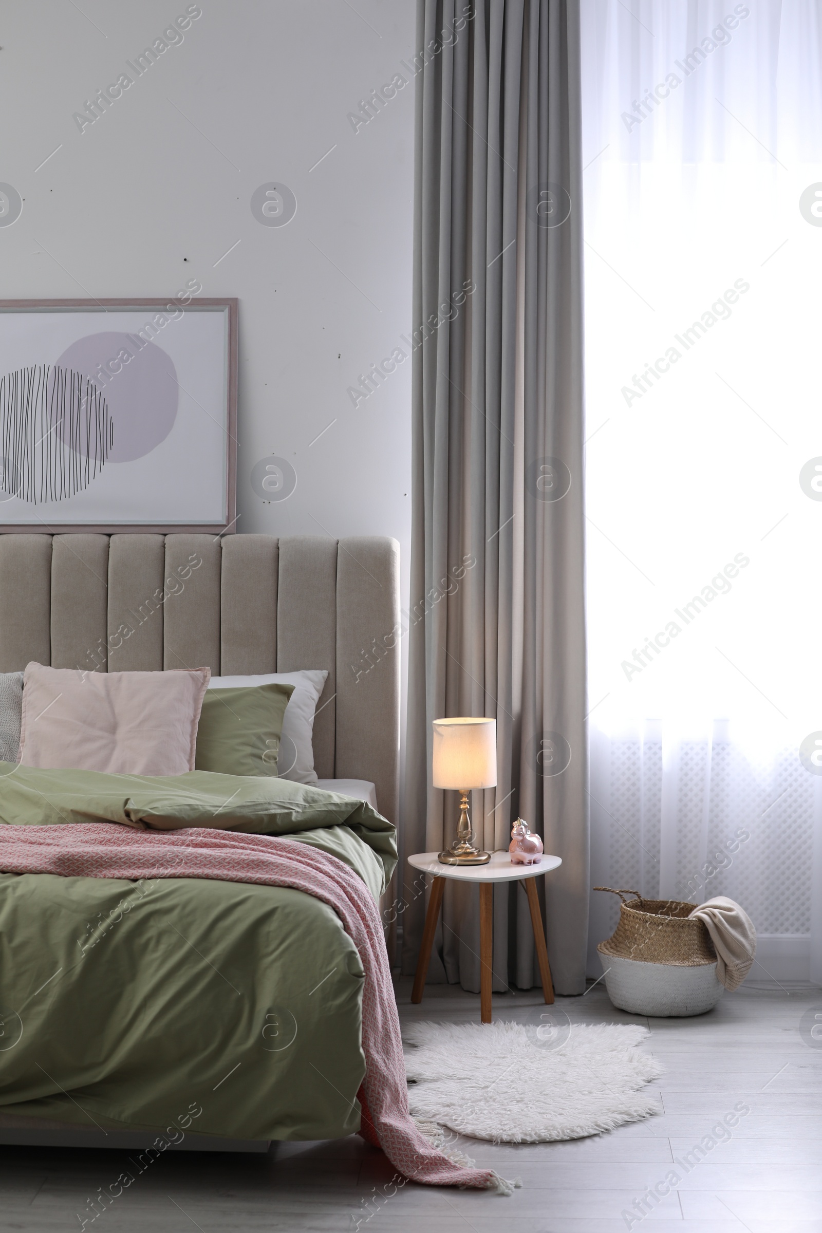 Photo of Comfortable bed with new pistachio linens in modern room interior