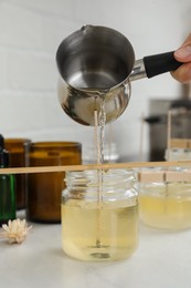 Photo of Woman making candles at white table, closeup