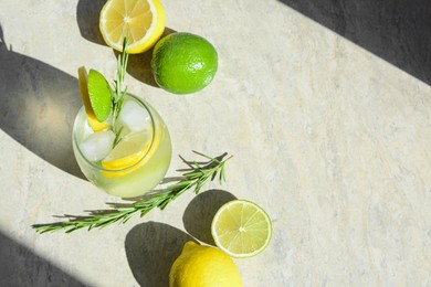 Photo of Tasty refreshing lemonade and ingredients on light grey table, above view. Space for text