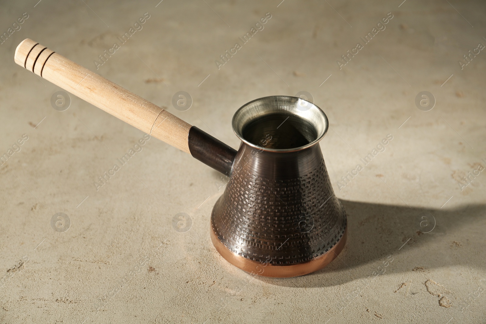 Photo of Beautiful copper turkish coffee pot on light table