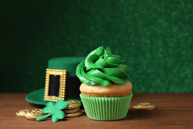 Composition with delicious decorated cupcake on wooden table. St. Patrick's Day celebration