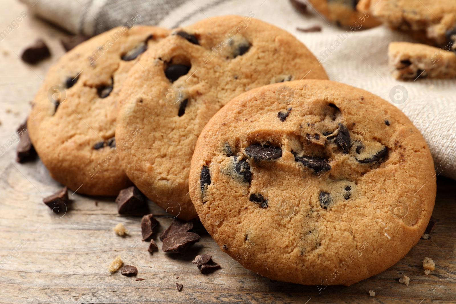 Photo of Delicious chocolate chip cookies on wooden table, closeup