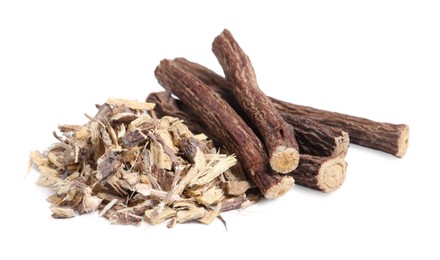 Photo of Dried sticks of liquorice root and shavings on white background