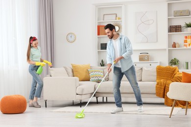 Photo of Spring cleaning. Couple tidying up living room together