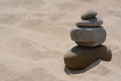 Photo of Stack of stones on beautiful sandy beach, space for text