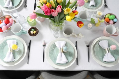 Photo of Festive Easter table setting with beautiful flowers, above view