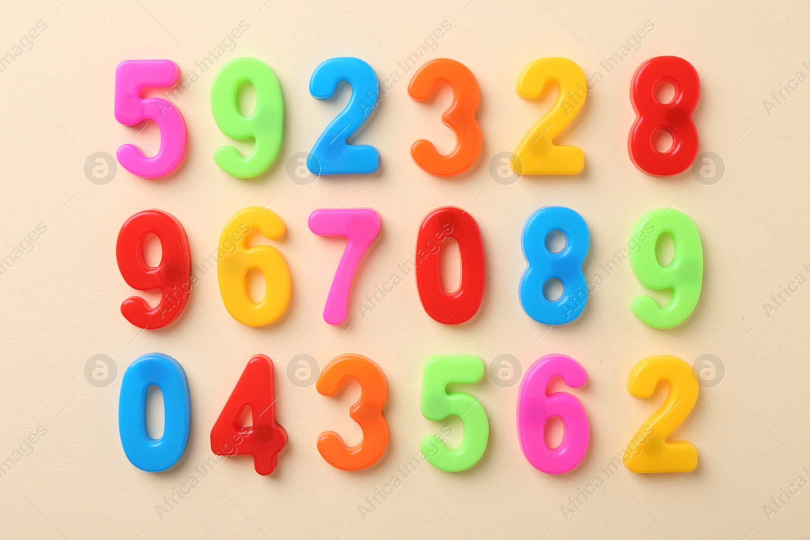 Photo of Colorful numbers on beige background, flat lay