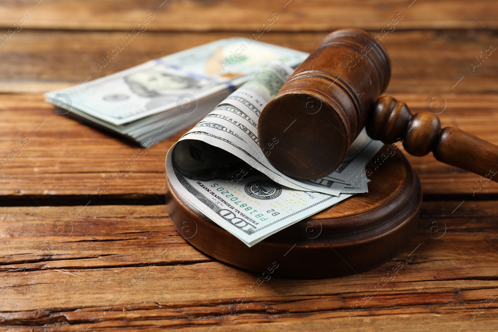 Photo of Judge's gavel and money on wooden table, closeup