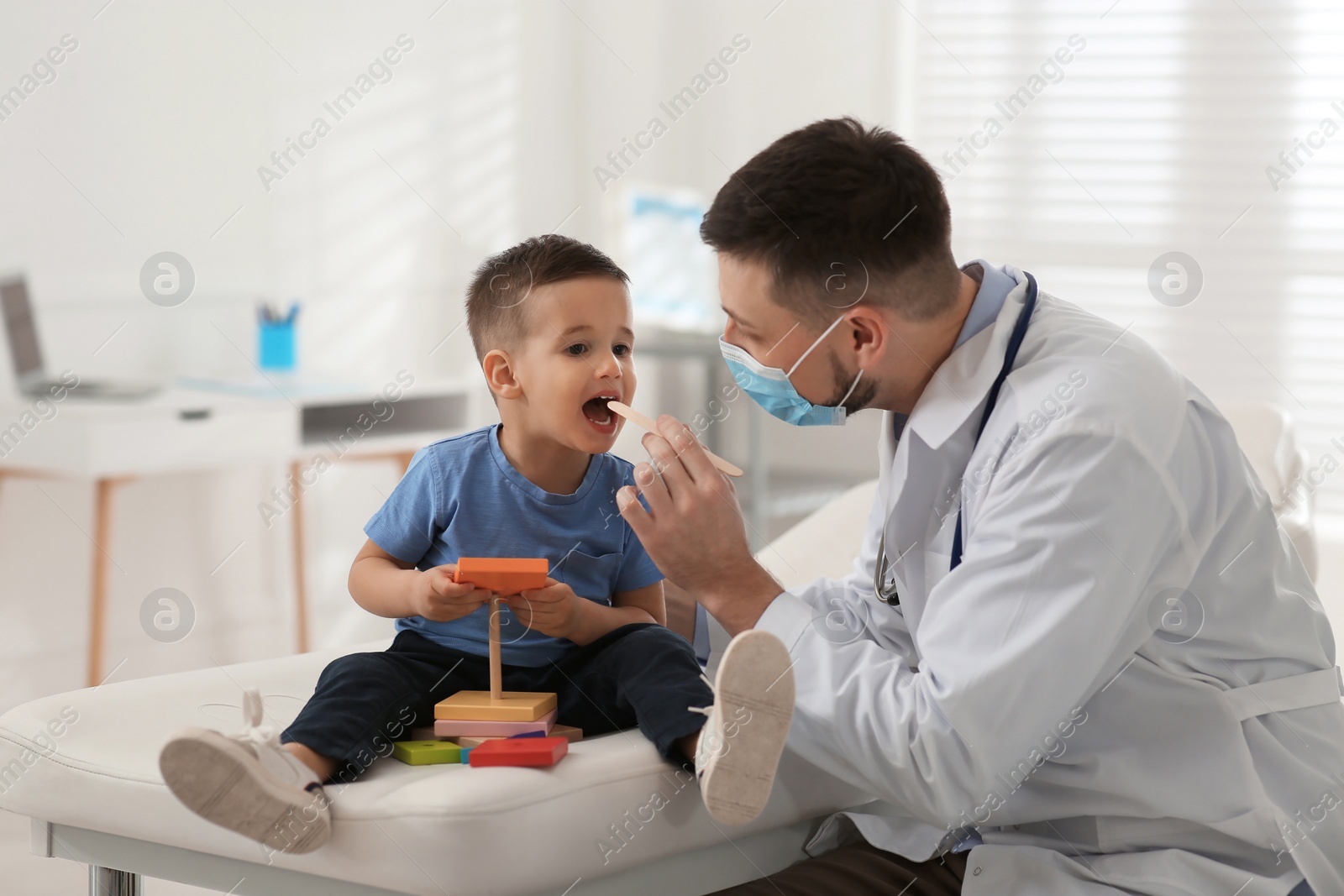 Photo of Pediatrician examining cute little boy at hospital