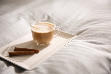 Photo of Tray with morning coffee on soft blanket. Space for text