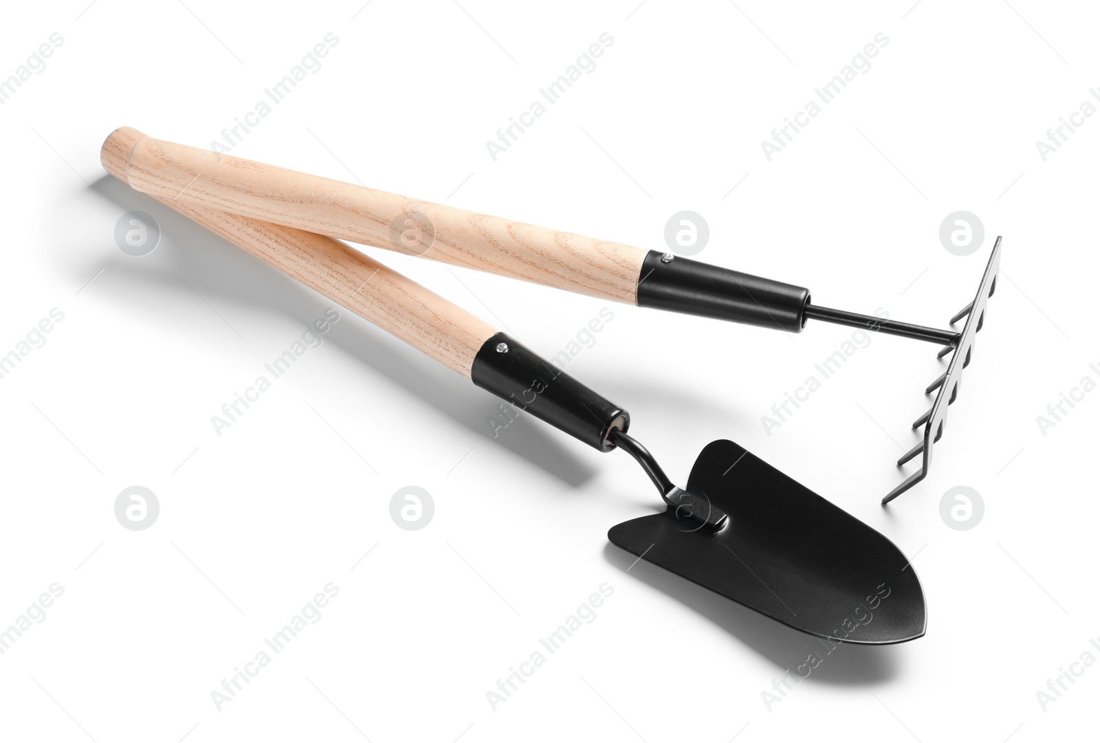 Photo of New rake and trowel on white background. Professional gardening tools