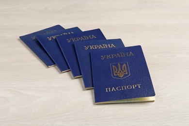 Photo of Many Ukrainian internal passports on wooden background
