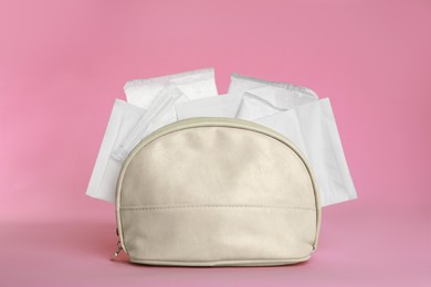 Photo of Bag with menstrual pads on pink background