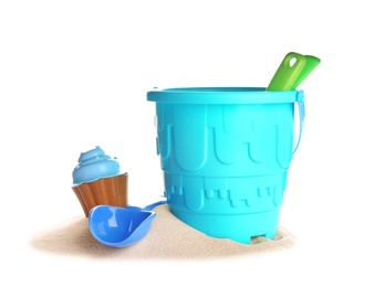 Set of plastic beach toys and pile of sand on white background