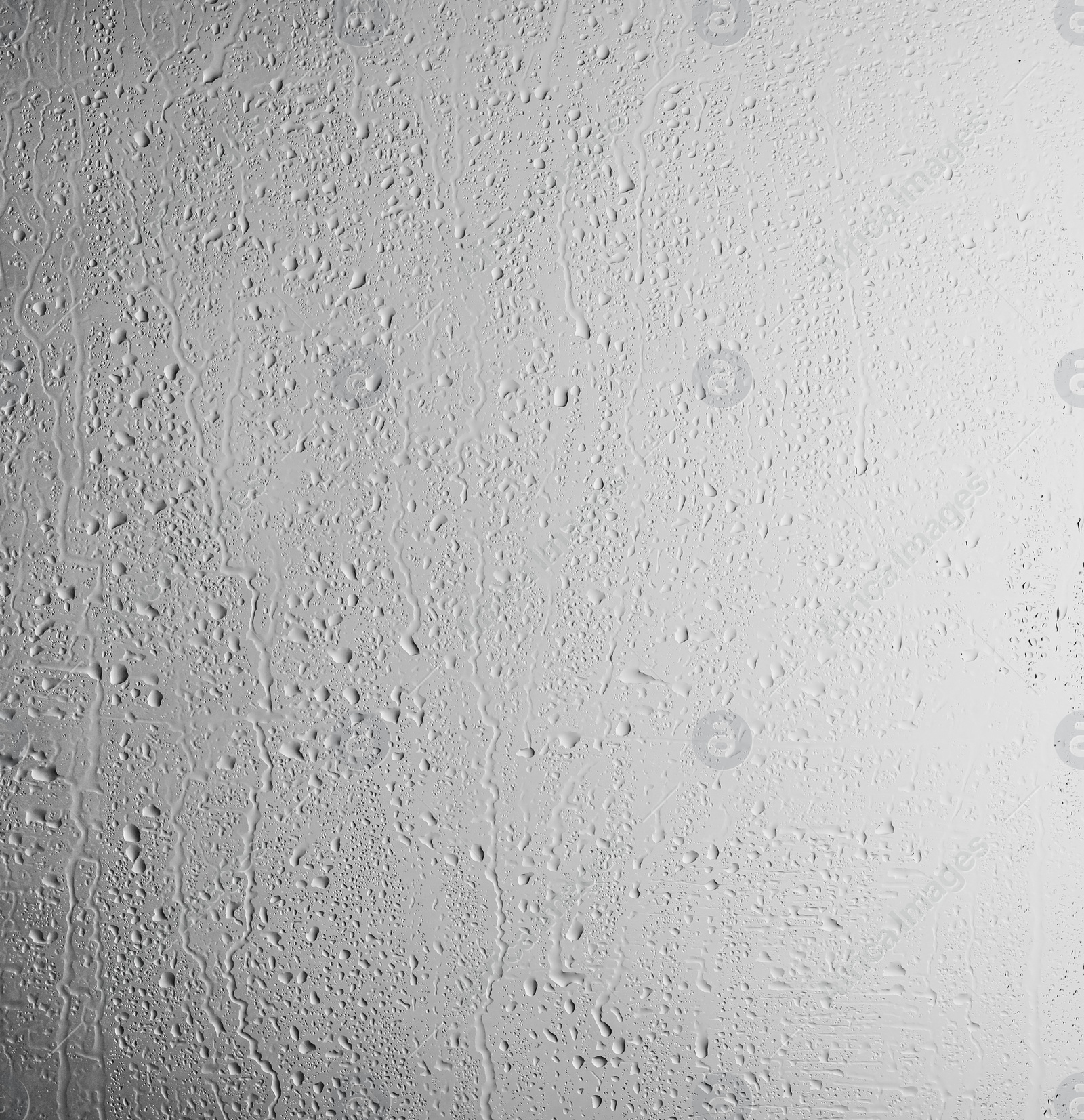 Photo of Rain drops on glass against light background