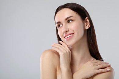 Portrait of beautiful young woman on light grey background. Space for text