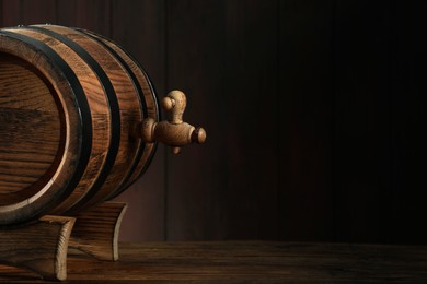 Photo of Wooden barrel with tap on table near wall. Space for text