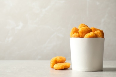 Delicious fried chicken nuggets on light grey table. Space for text