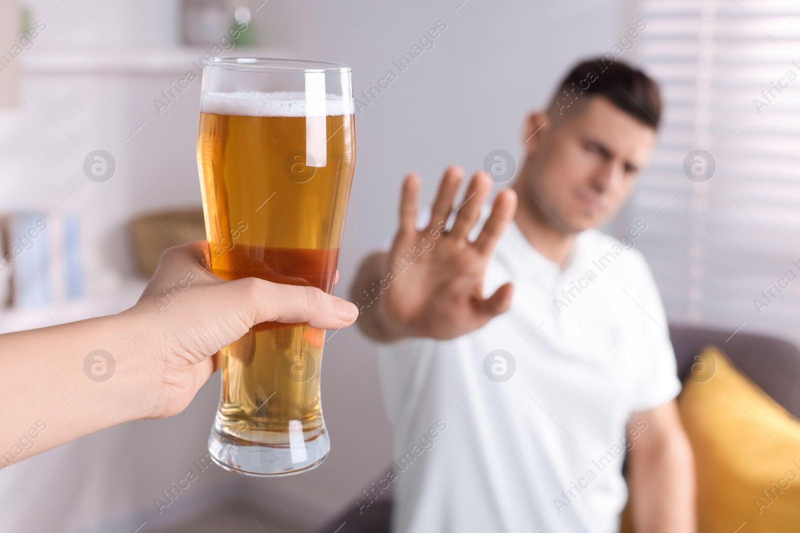 Photo of Man refusing to drink beer in kitchen, closeup. Alcohol addiction treatment