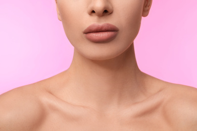 Woman with matte lipstick on pink background, closeup