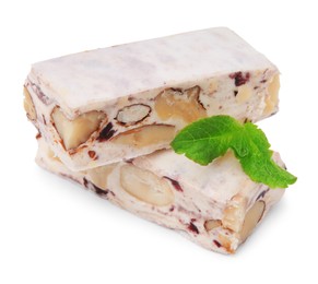 Pieces of delicious nougat and mint on white background