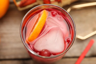 Photo of Tasty cranberry cocktail with ice cubes and orange in glass on table, above view