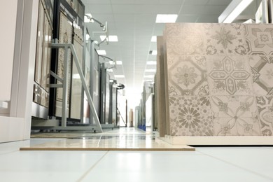 Photo of Assortment of tiles in store, low angle view. Many different samples indoors