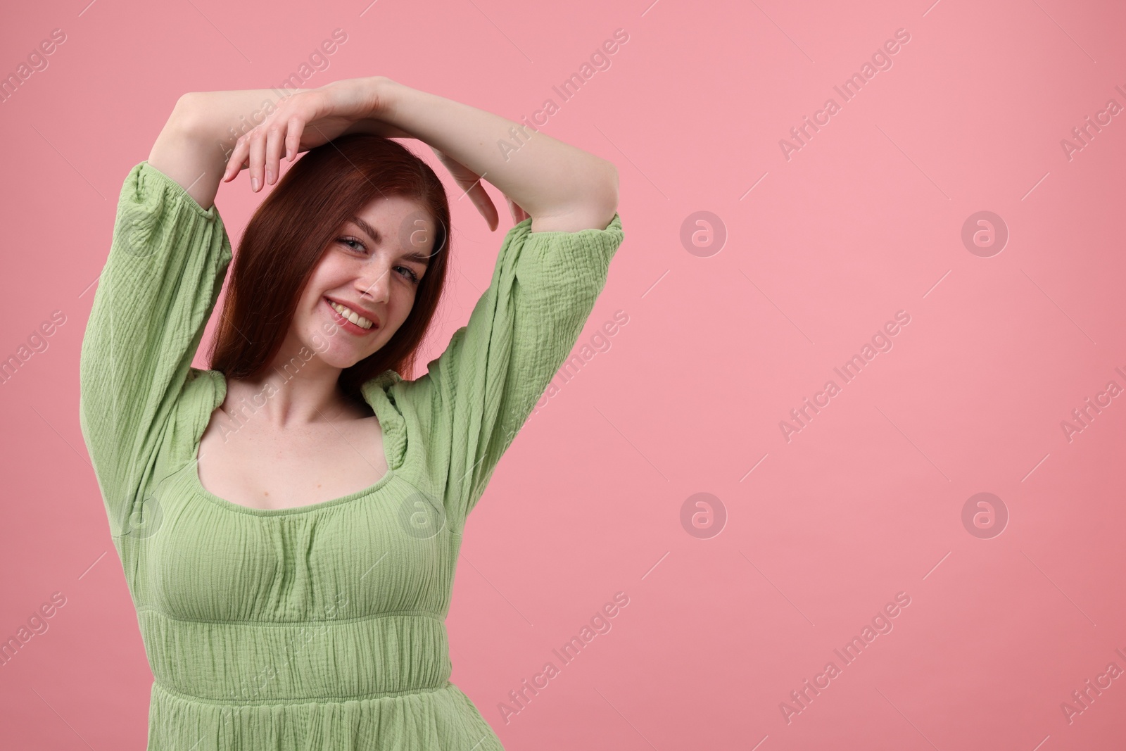 Photo of Portrait of smiling woman with freckles on pink background. Space for text