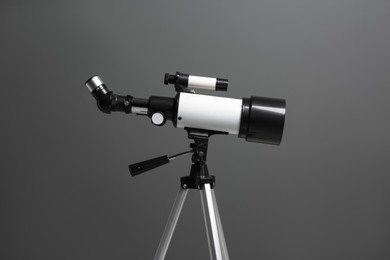 Photo of Tripod with modern telescope on grey background, closeup