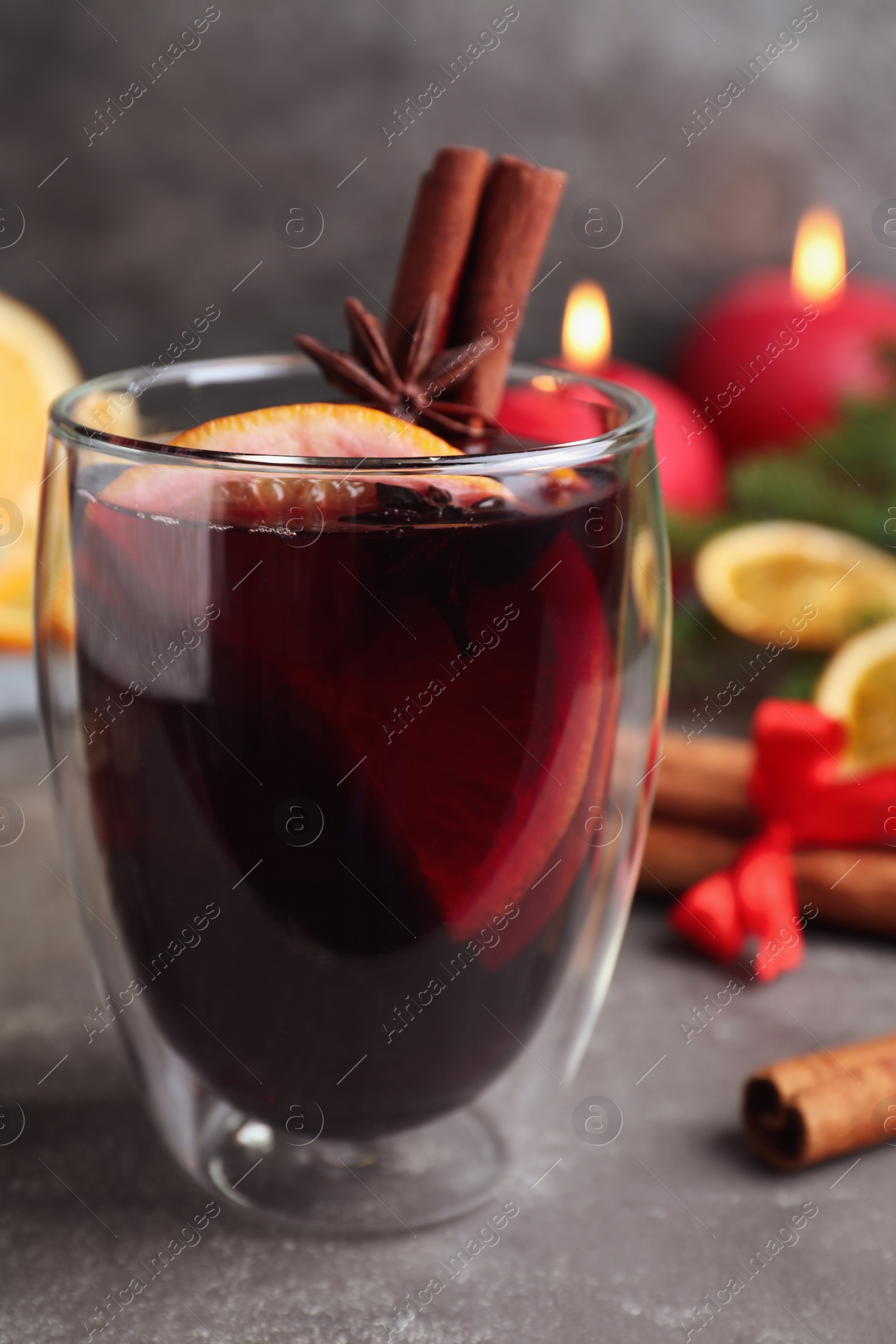 Photo of Aromatic mulled wine on grey table, closeup