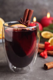 Photo of Aromatic mulled wine on grey table, closeup