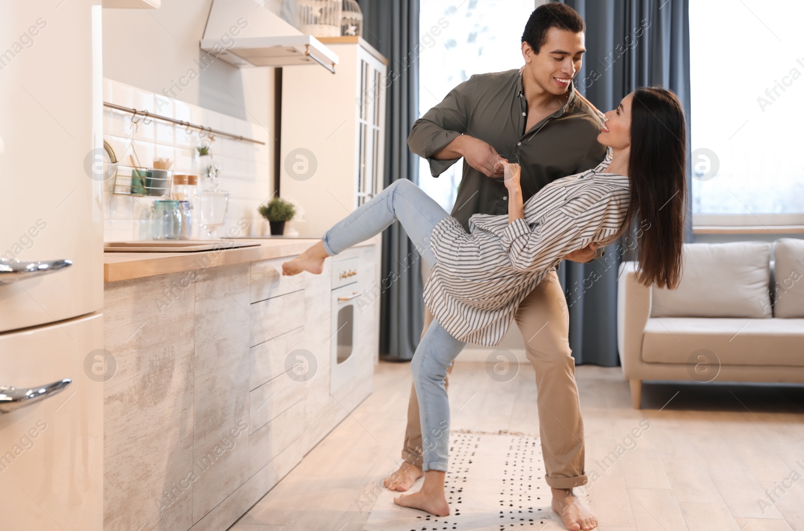 Photo of Lovely young interracial couple dancing at home