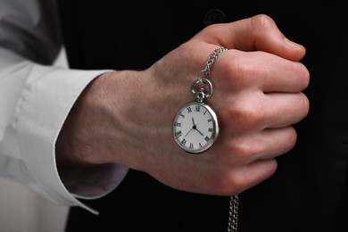 Photo of Man holding chain with elegant pocket watch, closeup