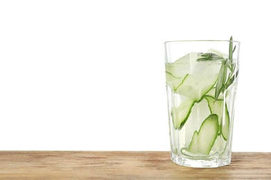 Photo of Glass of refreshing cucumber lemonade on wooden table against white background, space for text. Summer drink
