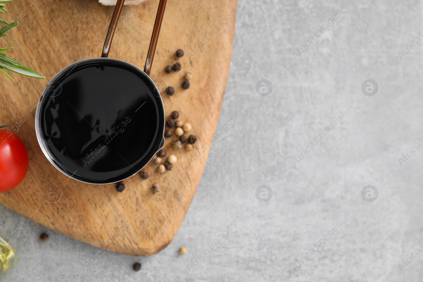 Photo of Organic balsamic vinegar and cooking ingredients on grey table, flat lay. Space for text