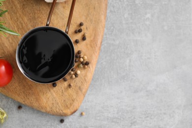 Photo of Organic balsamic vinegar and cooking ingredients on grey table, flat lay. Space for text