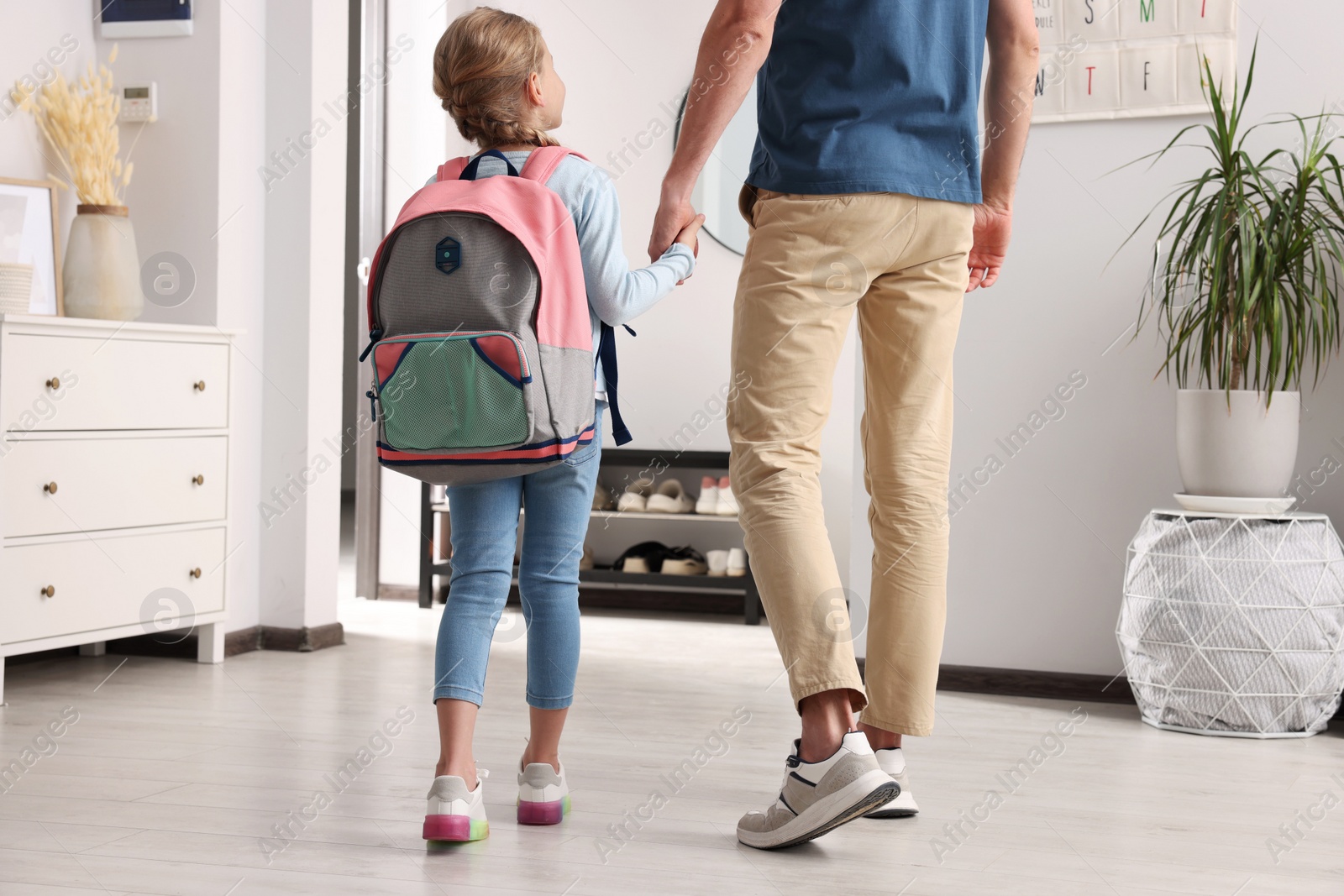 Photo of Little girl with father at home. Ready to go to school