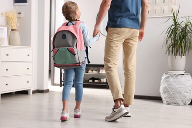 Photo of Little girl with father at home. Ready to go to school