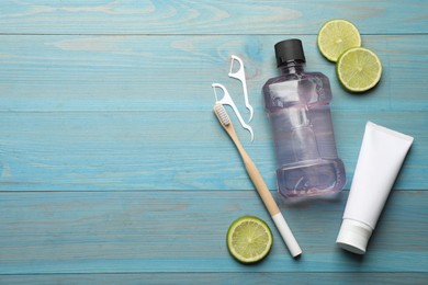 Flat lay composition with mouthwash and other oral hygiene products on turquoise wooden background. Space for text