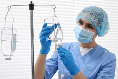 Photo of Nurse setting up IV drip in hospital